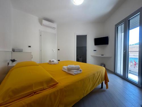 - une chambre avec un lit jaune et une couverture jaune dans l'établissement Domu Dina Affittacamere 1, à Tertenìa