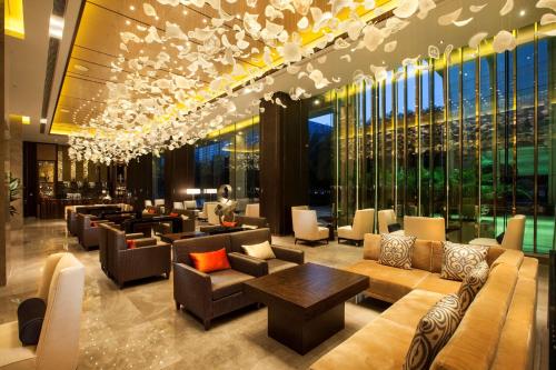 a hotel lobby with couches and tables and windows at Hilton Shenzhen Futian, Metro Station at Hotel Front Door, Close to Futian Convention & Exhibition Center in Shenzhen