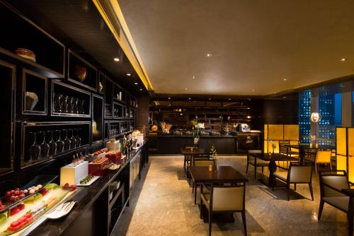 a restaurant with tables and chairs and a bar at Hilton Shenzhen Futian, Metro Station at Hotel Front Door, Close to Futian Convention & Exhibition Center in Shenzhen