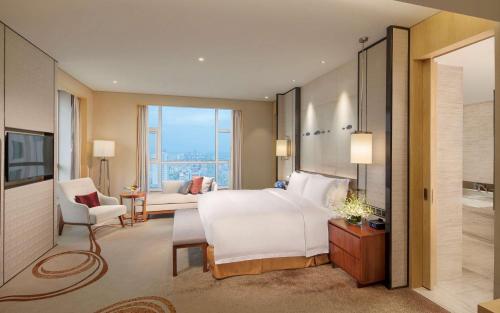 JimoにあるDoubleTree by Hilton Hotel Qingdao-Jimo Ancient Cityのベッドルーム1室(ベッド1台付)、リビングルームが備わります。