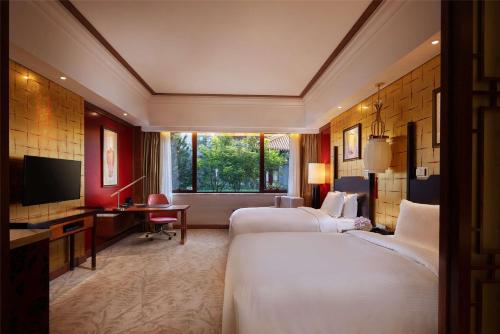 een hotelkamer met 2 bedden en een televisie bij Hilton Tianjin Eco-City in Binhai