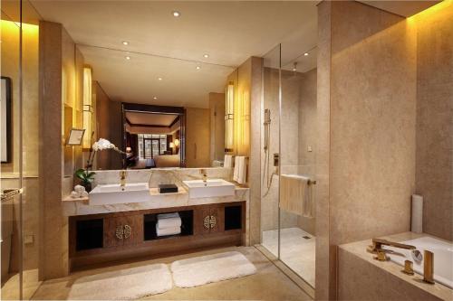 a large bathroom with two sinks and a shower at Hilton Tianjin Eco-City in Binhai