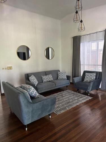 a living room with a couch and two chairs at Villa REYDISIA in Saint-Laurent du Maroni