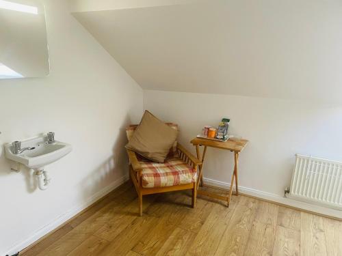 愛丁堡的住宿－Cosy loft room in Morningside, Edinburgh，一间带水槽、椅子和桌子的浴室