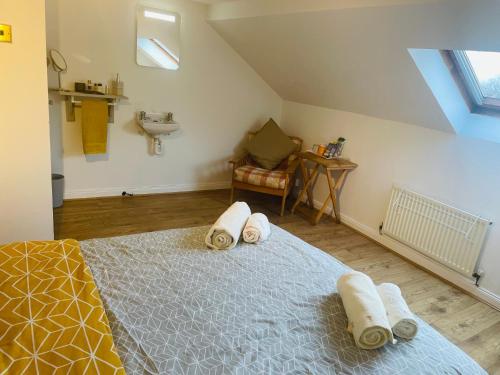 um quarto com uma cama com toalhas em Cosy loft room in Morningside, Edinburgh em Edimburgo