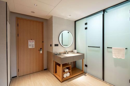 La salle de bains est pourvue d'un lavabo et d'un miroir. dans l'établissement Hilton Garden Inn Guizhou Maotai Town, à Maotai