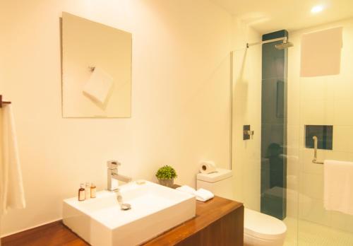 a white bathroom with a sink and a shower at Kuxtal 3 Bedroom Downtown Apartment by Casago in Playa del Carmen