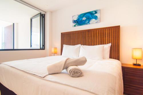 a bedroom with a large white bed with two lamps at Kuxtal 3 Bedroom Downtown Apartment by Casago in Playa del Carmen