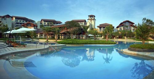 uma grande piscina em frente a um resort em Hilton Wuhan Optics Valley em Wuhan