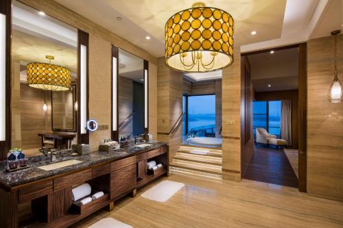 bagno con lavandino e grande specchio di Hilton Wuhan Optics Valley a Wuhan