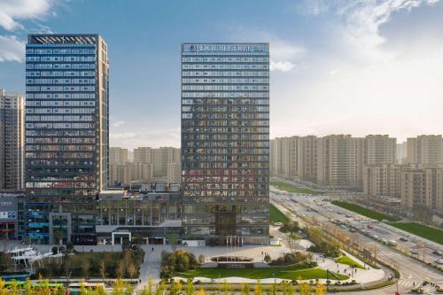 a tall building in the middle of a city at Doubletree By Hilton Xian Fengdong in Xi'an