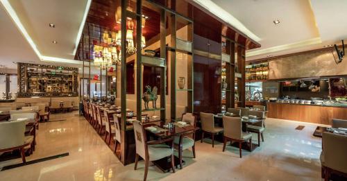 un restaurante con mesas y sillas y un bar en Hilton Xi'an, en Xi'an