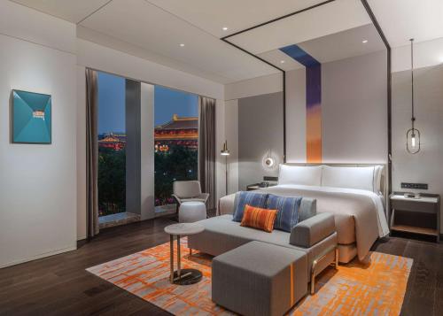 a bedroom with a king sized bed and a couch at Canopy by Hilton Xi'an Qujiang in Xi'an