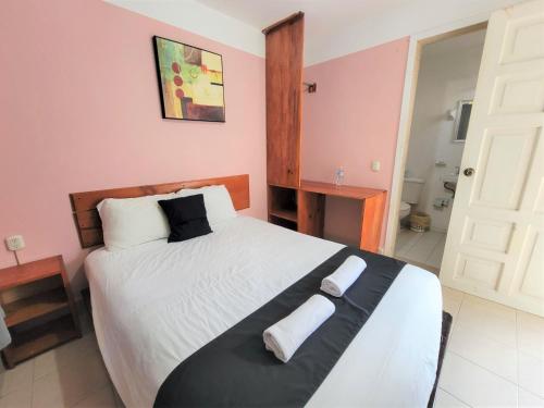 1 dormitorio con 1 cama grande y 2 toallas. en Hotel Dulce Luna, en San Cristóbal de Las Casas