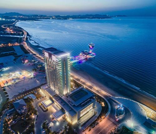 an aerial view of a hotel on the beach at night at Hilton Yantai Golden Coast in Yantai