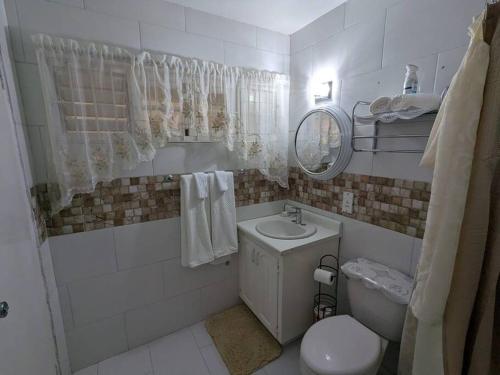 uma casa de banho com um lavatório, um WC e um espelho. em Relaxing Space with an Awesome View em Lodge