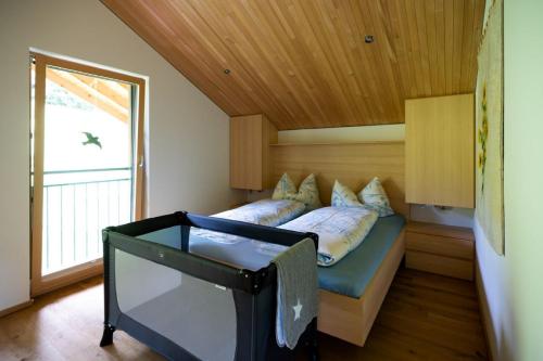 ein Schlafzimmer mit einem Bett in einem Zimmer mit einem Fenster in der Unterkunft Ferienhaus Bergblick Bregenzerwald in Bregenz