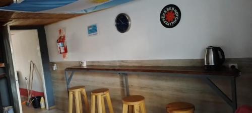 a room with a table and some stools at Hostel Huellas Patagonicas in Junín de los Andes