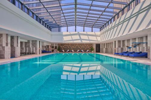 a large swimming pool with a large ceiling at Hilton Yancheng in Yancheng