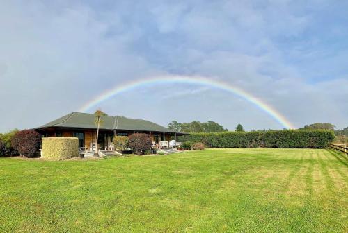 a rainbow in the sky over a house at Heaven's Rest B&B in Pukekohe East