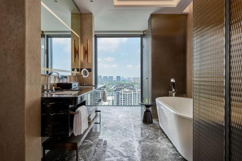 a bathroom with a tub and a sink and a bath tub at Hilton Yancheng in Yancheng