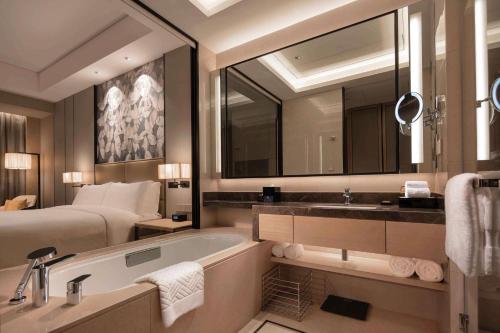 y baño con cama, bañera y lavamanos. en Doubletree By Hilton Yangzhou en Yangzhou