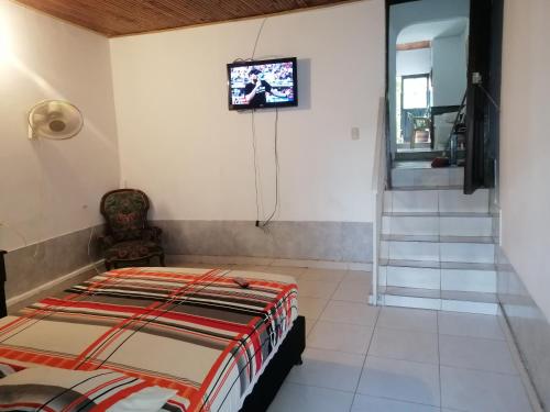 1 dormitorio con 1 cama y TV en la pared en Casa de relajación low cost, en La Dorada