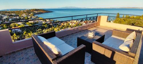 希俄斯的住宿－Villa Marisia，阳台配有两把椅子和一张桌子,享有海景。