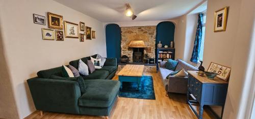 a living room with two couches and a table at Goonearl Simply Stay in Scorrier