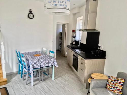 une cuisine avec une table et une cuisine avec une cuisinière dans l'établissement Lis du Japon, à Saint-Georges-de-Didonne