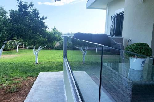 a balcony with a view of a yard at Luxury Home with Garden in the Suburbs in Kalamata