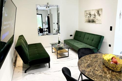 a living room with a green couch and a table at Luxury Home with Garden in the Suburbs in Kalamata