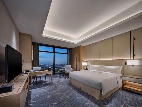 a hotel room with a bed and a television at Hilton Beijing Tongzhou in Beijing