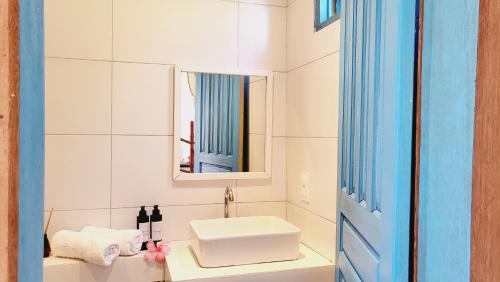 uma casa de banho branca com um lavatório e um espelho em Casa Linda Boipeba na Ilha de Boipeba