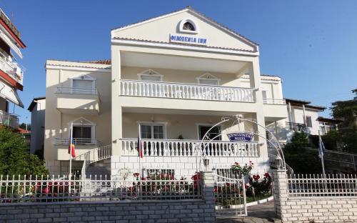 a white building with a white fence in front of it at Philoxenia Inn in Limenas