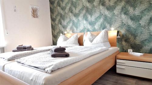 a bedroom with a large bed with towels on it at Seeblick-Ferienwohnung im "Ferienhaus Agger-Blick" mit traumhafter Sonnen-Terrasse, Sauna, E-Kamin & Kajak in Gummersbach