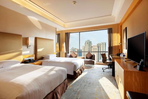 廈門市にあるヒルトン シアメンのベッド2台、薄型テレビが備わるホテルルームです。