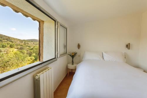 una camera con un letto bianco e una finestra di Cosy Gîte in Gabian with Beautiful River and Vineyard Views a Gabian