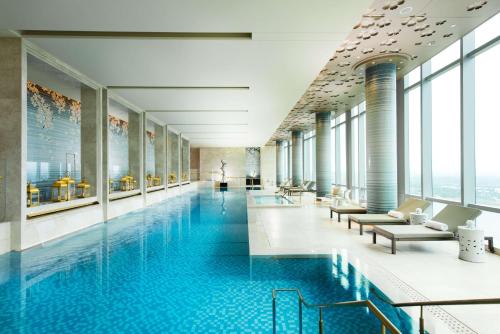 a swimming pool in a building with windows at Waldorf Astoria Chengdu in Chengdu