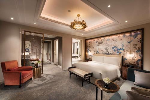 a bedroom with a bed and a couch and a chair at Waldorf Astoria Chengdu in Chengdu