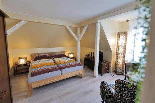 a bedroom with a bed and a tv in it at Elena Kempf Haaratelier & Guesthouse in Braunfels