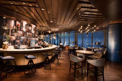 a restaurant with a bar and tables and chairs at Waldorf Astoria Chengdu in Chengdu