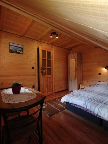 a bedroom with a bed and a table in a room at Agroturystykadomkistawisko in Solina
