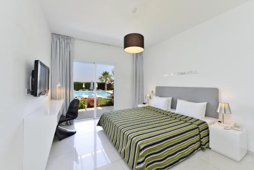 a hotel room with a bed and a window at Mon Repos Hotel in Ayia Napa