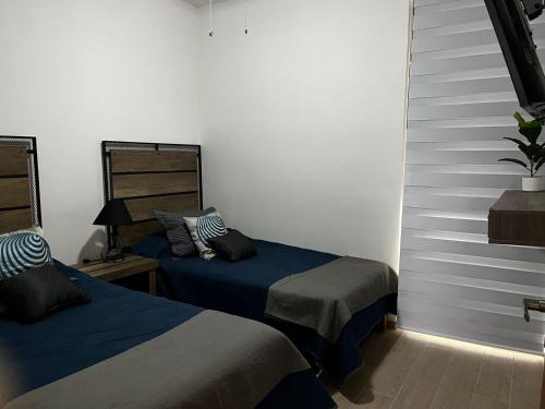 um quarto com 2 camas e uma escada em Departamento Lago de Chapala con Roof Top. em Jocotepec