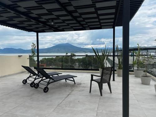 a patio with a bench and a table and a chair at Departamento Lago de Chapala con Roof Top. in Jocotepec