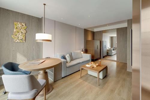 a living room with a table and a couch at DoubleTree by Hilton Taipei Zhongshan in Taipei