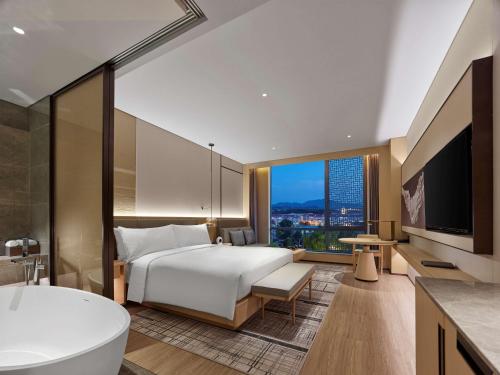 una camera d'albergo con un grande letto e una vasca di Doubletree By Hilton Beijing Badaling a Yanqing