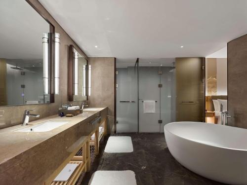 a bathroom with a large tub and two sinks at Doubletree By Hilton Beijing Badaling in Yanqing