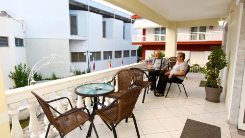 dwie osoby siedzące na balkonie budynku w obiekcie Philoxenia Inn w mieście Limenas
